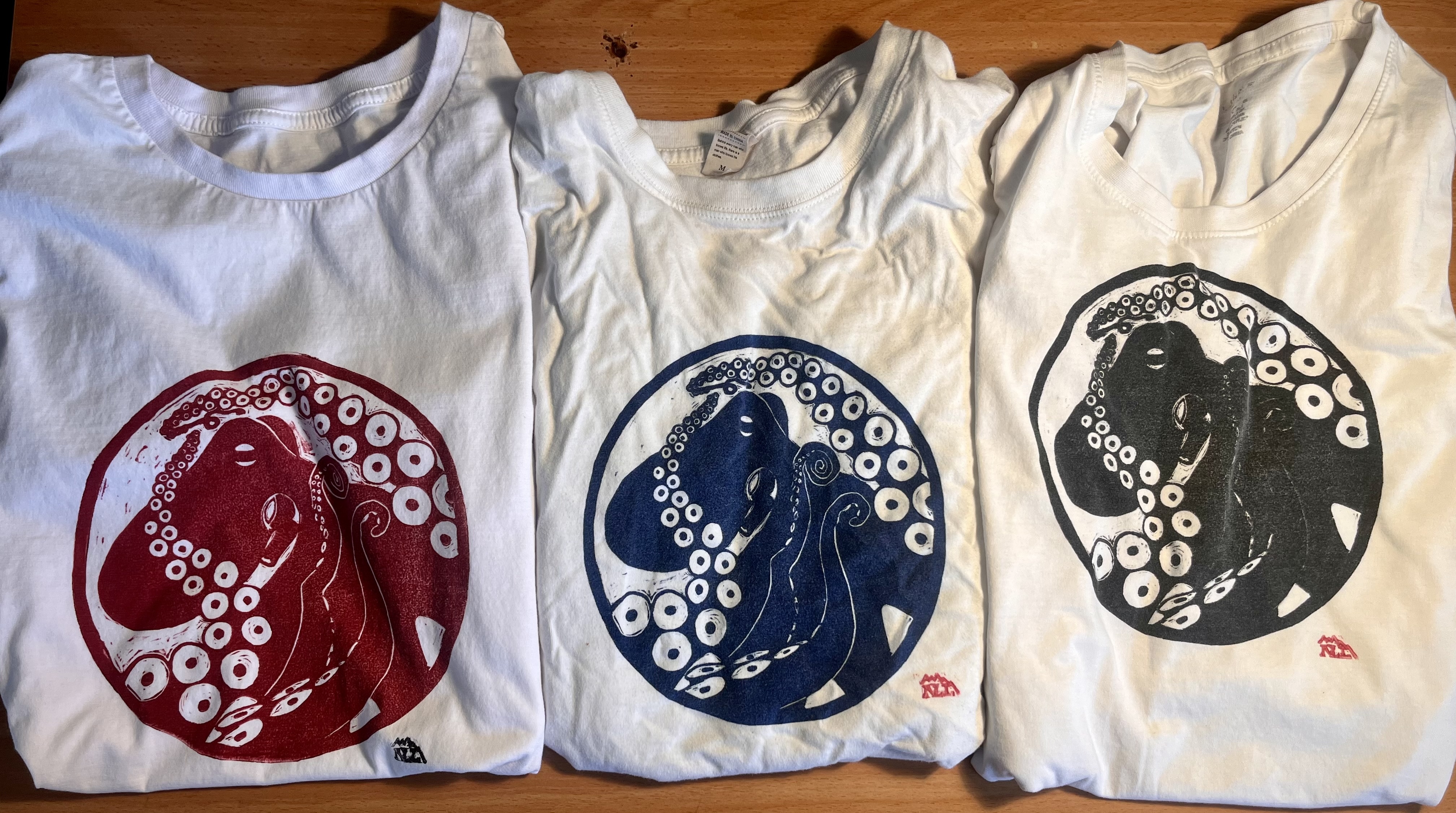 A row of hand-printed shirts, each featuring an octopus linocut